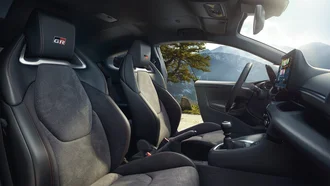 Cockpit des Toyota GR Yaris im Profil - Sonne, Berge und Bäume im Hintergrund