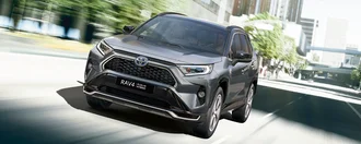 RAV4 Plugin Hybrid dynamisch unterwegs i einer modernen Innenstadt