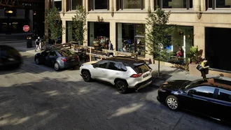 Weißer Toyota Rav4 im verkehrsberuhigten Bereich einer modernen Stadt geparkt