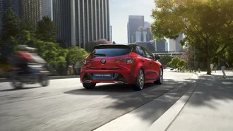 Roter Toyota Corolla in dynamischer City-Umgebung