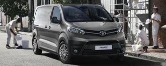Grauer Toyota Proace von vorne auf einer Baustelle, daneben stehen Maler
