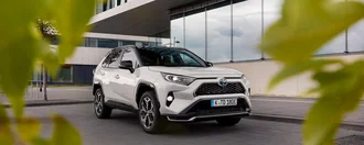 Weißer Toyota Rav4 von vorne aus einem Gebüsch raus fotografiert