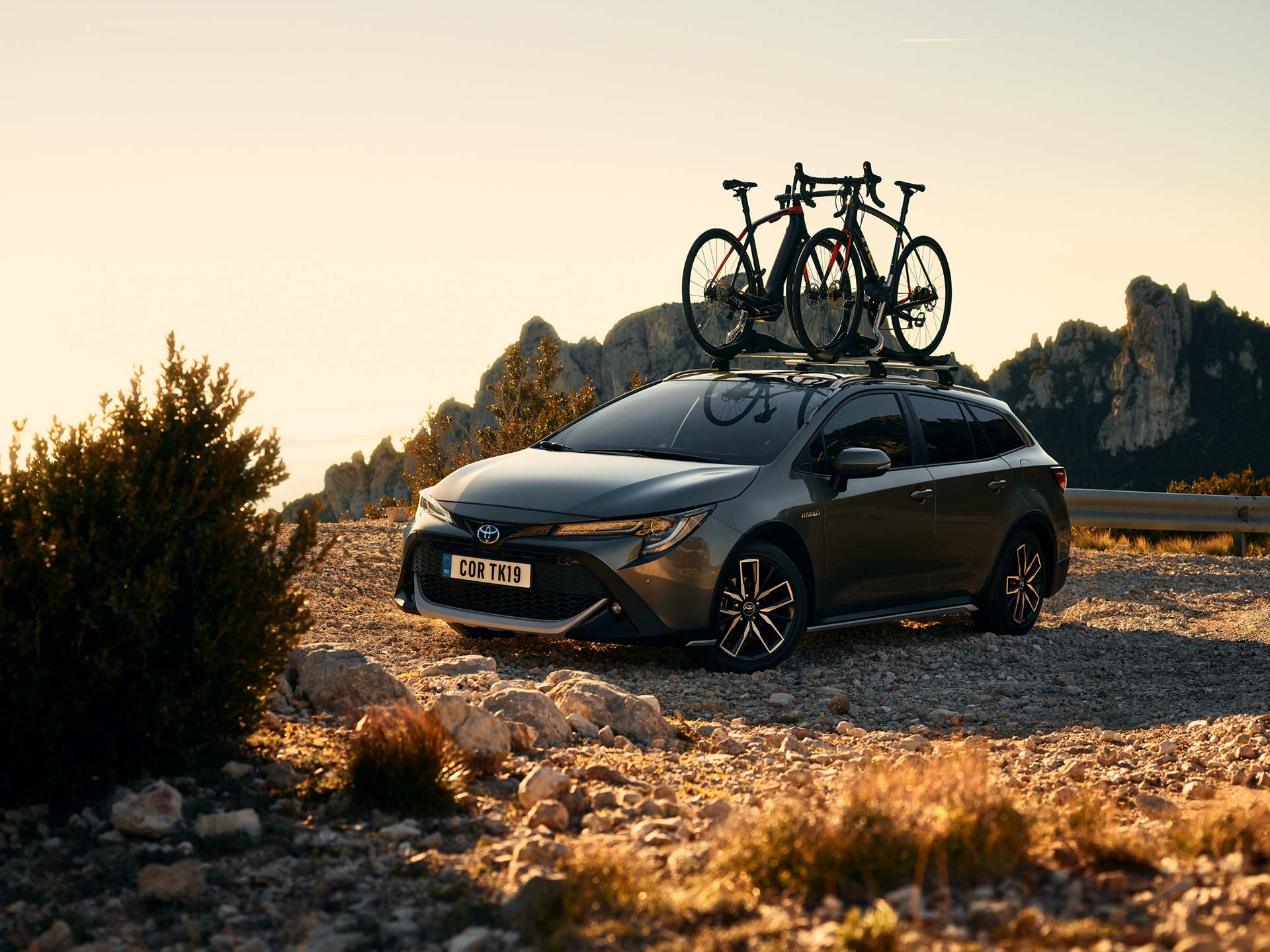 Toyota COROLLA Touring Sports mit Fahrrädern auf Dachträger in der Wildnis bei Sonnenuntergang 